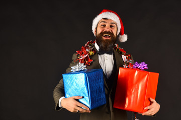 Businessman with cheerful face holds present boxes.