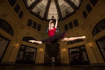 Obraz na płótnie Canvas Ballerina Natalia Horsnell doing a split jump in the Oktogon public urban passageway in Zagreb, Croatia.