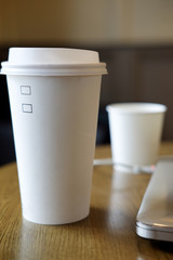 White disposable paper cup with plastic lid