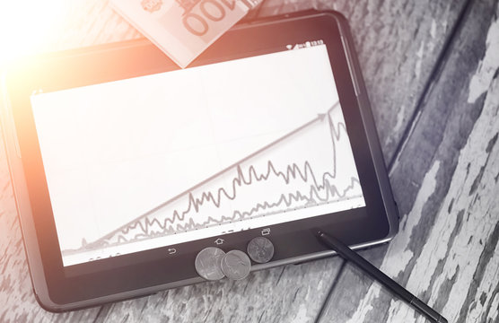 The graph of income growth. Electronic tablet with a graph of gr