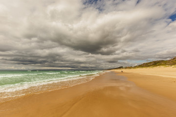 stormy sea with sandy beach and dark clouds