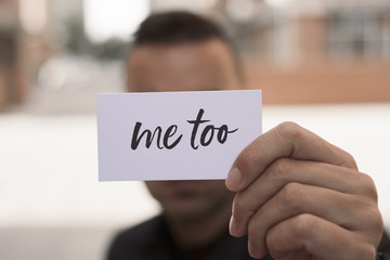 man showing a note with the text me too