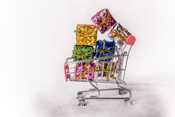 miniature shopping trolley loaded with wrapped gifts