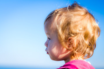Little blonde girl making a face with blue background