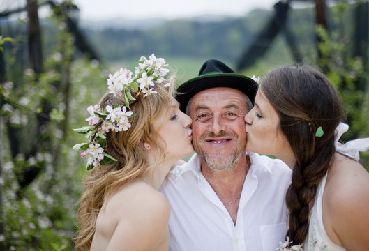 Two young women kissing a fruit farmer, Riegersburg, Styria, Austria