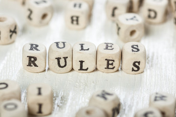 Rules word written on wood block.