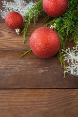 Christmas holiday decorations balls, spruce branches, cones on a wooden background with copy space flat view, concept of the new year