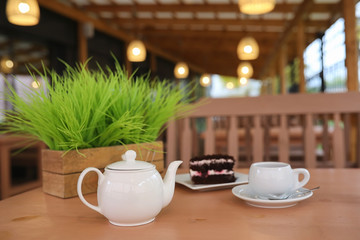 Kettle with a drink and dessert in a street cafe. Tea in the ket