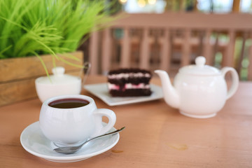Kettle with a drink and dessert in a street cafe. Tea in the ket