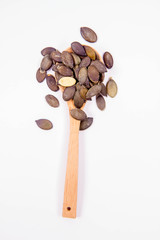 A spoon of Pumpkin seeds on a white background