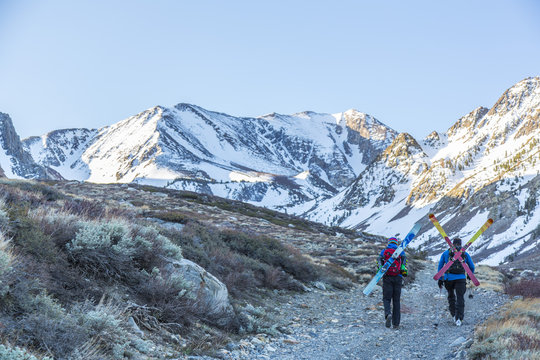 Two skiers carrying their skis on the back, Mammoth Lakes, California, USA