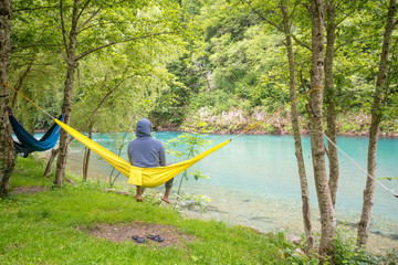  Man relax in a hammock overlooking the mountains and the river