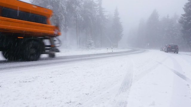 A truck snowplow is clearing the road of snow on a federal street in the Taunus area in Germany