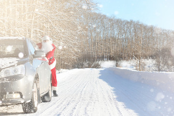 Santa Claus comes with gifts from the outdoor. Santa in a red su