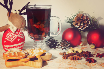 New Year celebratory table with mulled wine, ingredients and cookies, toy deer and Christmas decorations nearby