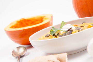 Pumpkin soup and pumpkins, pumpkin seeds, ginger and garlic on a white background