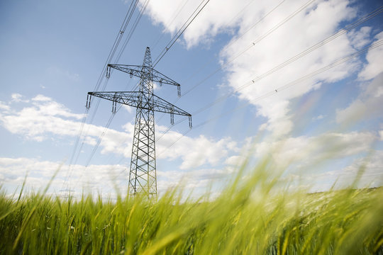 View of electricity pylon in field against cloudy sky