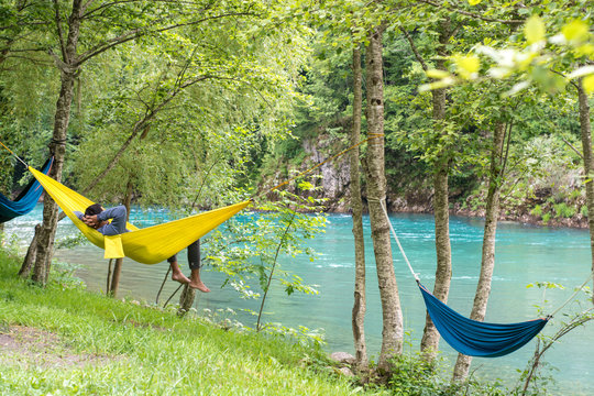  Man relax in a hammock overlooking the mountains and the river