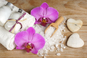 Spa set with white towels, sea salt, wooden spatula and bright orchid flower, stones in the form of hearts