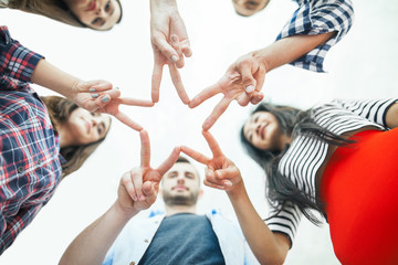 Five young smiling people make star shape from fingers