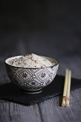 Scodella di riso basmati e riso rosso crudo su tavolo in legno. Cucina orientale