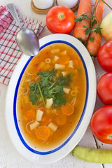 Minestrone soup in plate on white wooden table