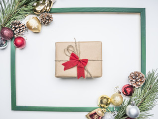 Christmas composition in a frame lined with Christmas decorations and a gift in the middle, top view