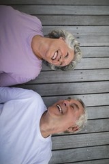 Overhead view of happy senior couple lying on wooden floor