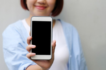 Woman hands holding smart phone with blank screen background for mock up, template, technology and lifestyle concept