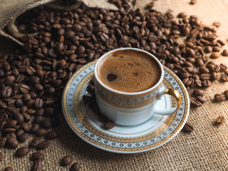 Espresso coffee Cup with beans on a burlap background.
