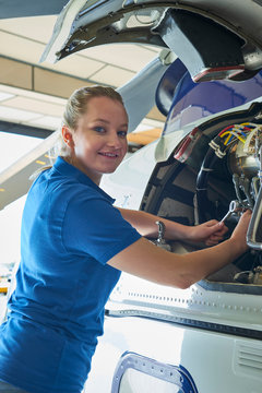 Portrait Of Female Aero Engineer Working On Helicopter In Hangar