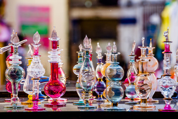 Colorful glass perfume bottles displayed on a shelf in an Egyptian market