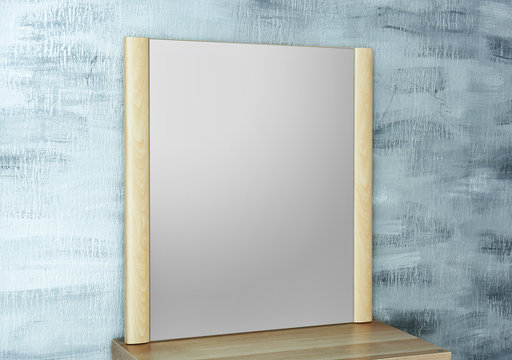 Modern mirror on table near color wall