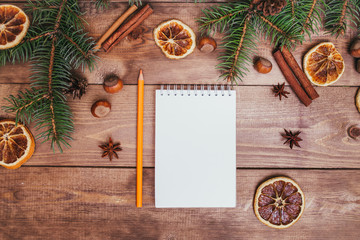 Christmas greeting card and food decor on wooden table with fir tree. Top view with copy space