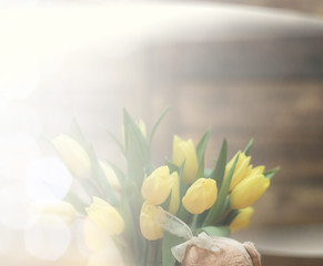  bouquet of yellow tulips in a vase on the floor