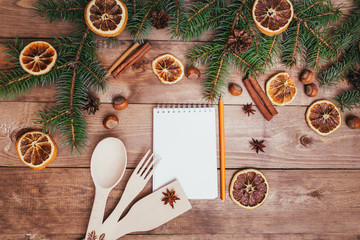 Christmas greeting card and food decor on wooden table with fir tree. Top view with copy space