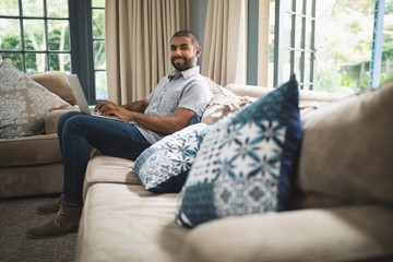 Portrait of man using laptop while sitting at home