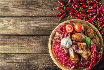 Food tray with delicious salami, pieces of sliced ham, sausage, tomatoes, salad and vegetable.