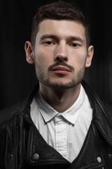 Male portrait in leather jacket in studio