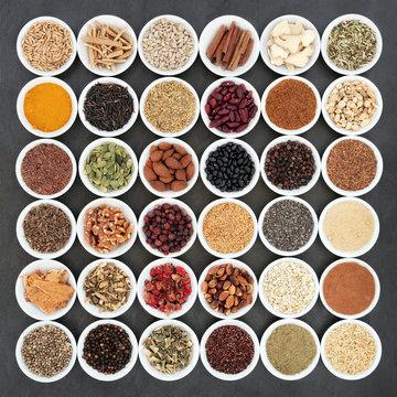 Herbal medicine and food ingredients to maintain a healthy heart. Large collection in porcelain bowls on slate background. Top view.