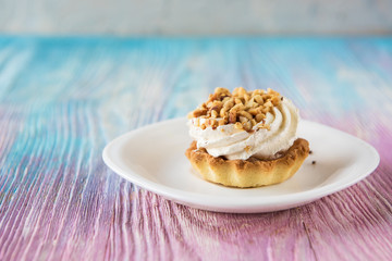 Tasty mini cake with nuts on a color gradient background