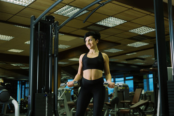 Fototapeta na wymiar Close up - body sport woman. Sporty woman exercising with dumbbells in gym