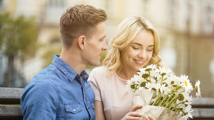 Happy girl smelling nice flowers, gift from beloved boyfriend, romantic date