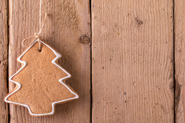Christmas gingerbread hanging over wooden background.