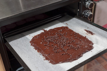 The workers bring the mixed chocolate to the oven. To make chocolate brownie crackers