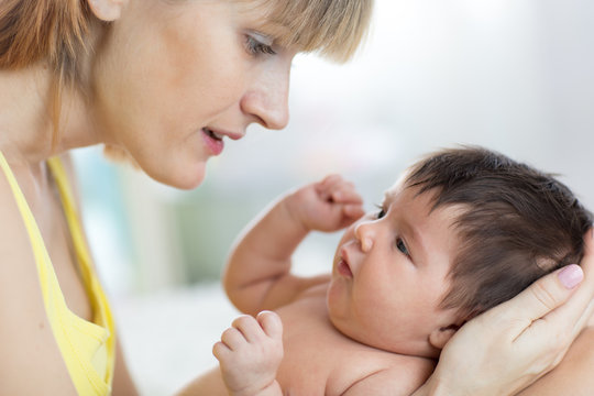 Portrait of beautiful young mom and her sweet little baby looking at each other, close up