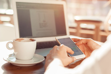 a girl is sitting at a wooden table in a cafe, drinking coffee a