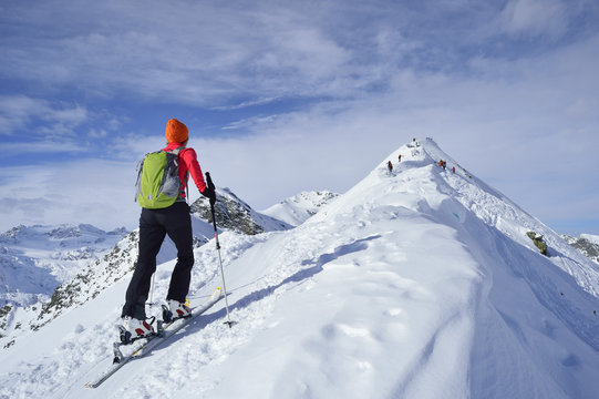 Rear view of woman cross country skiing on mountain top, Tyrol, Italy