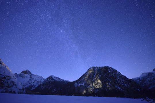 Scenic view of mountain range against starry sky