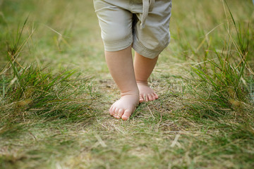barebood baby feet on a grass healthy walk development 